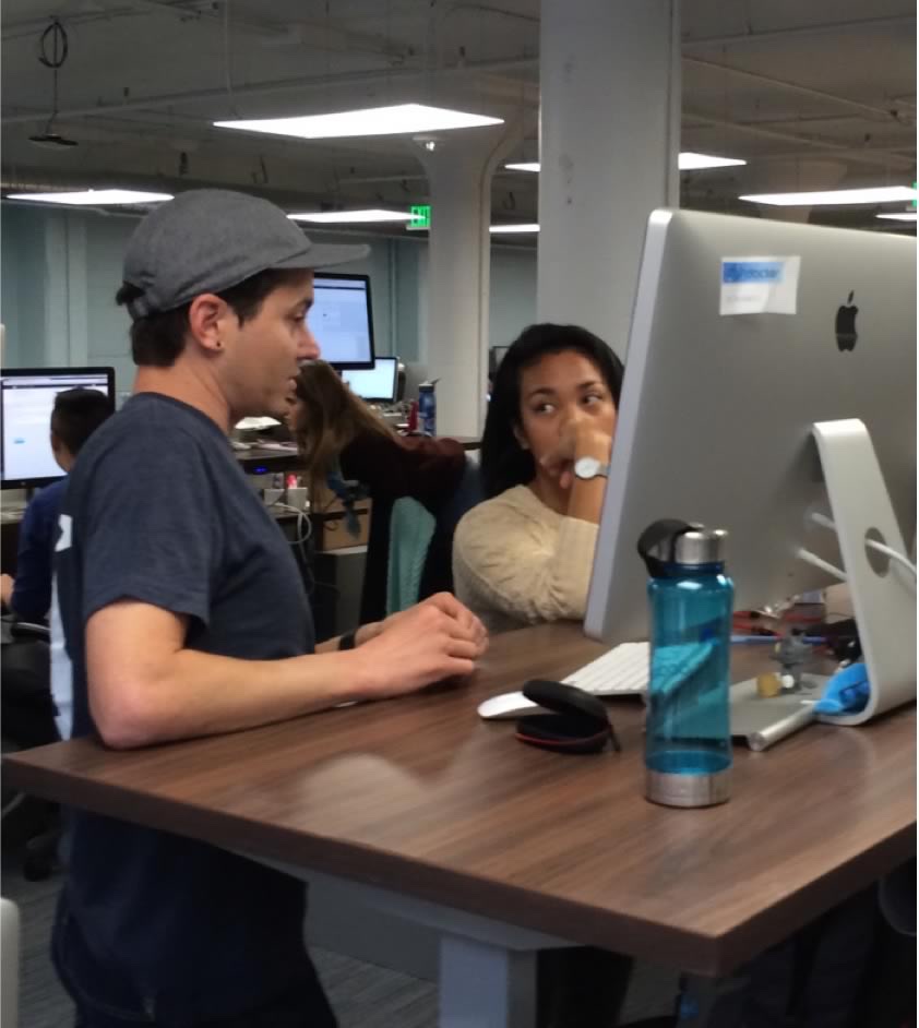 Two people working through a design at an iMac in Docker’s open office